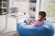 © deagreez - Full length photo of cute adorable girl daughter remote lesson sit bean bag education from home indoors
