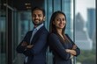 © Elmira - Two Indian professionals stand back-to-back, arms crossed, embodying teamwork and confidence in a sleek city office with glass windows