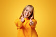 © Prostock-studio - I like it. Portrait of joyful teenage girl showing thumbs up and smiling at camera, orange background with copy space