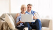 © Prostock-studio - Happy mature couple surfing internet on laptop, spending weekend at home