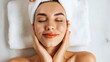 © sommersby - A woman relaxes with her eyes closed, enjoying a facial treatment at a tranquil spa