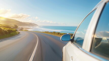 A car is driving down a road near the ocean