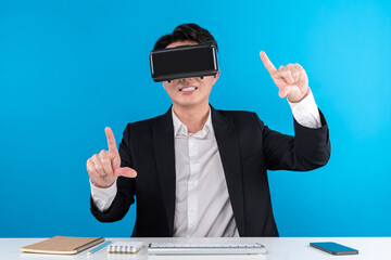 Asian businessman looking through VR connecting zoom out in analyzing business world news futuristic metaverse analyzing innovation technology virtual reality isolated blue copyspace. Contrivance.