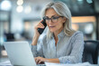 © Imane - Woman, phone call and documents with laptop in office for investment, plan or update on client finance. Mature financial advisor, discussion and work with tech for foreign exchange, trading or report