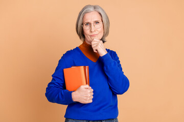 Sticker - Photo portrait of nice senior woman thoughtful hold books wear trendy blue outfit isolated on beige color background