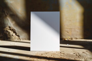 Sticker - A blank piece of paper sits on top of a wooden table, perfect for writing or drawing