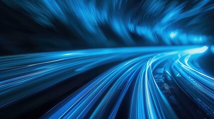 A long exposure shot of a road with car headlights creating streaks of light in a dark blue.