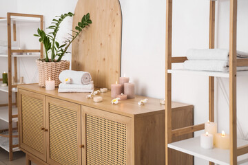 Poster - Towels with burning candles and plumeria flowers on commode in spa salon