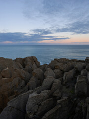 Wall Mural - Layered rock formation at the shore.