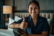 © Halina Berah - Pretty smiling maid with white gloves and apron showing thumbs up to camera in hotel room