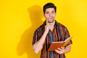 Wall Mural - Photo of nice young man hold pen book wear shirt isolated on yellow color background