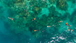 © Mat Hayward - Aerial drone view of people snorkeling over deep coral reefs watching endangered manta ray hunt from krill. The tourists are engaging in a popular snorkel trip on the island of Bora Bora.