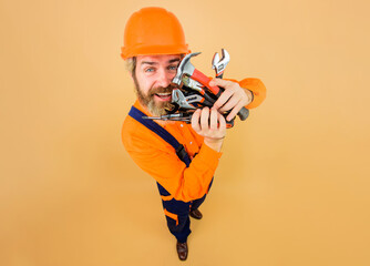 smiling bearded man in protective hard hat with repair tools. building industry. male builder in saf