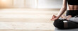 © Prostock-studio - Yoga, meditation, pilates concept. Close up of yoga woman sitting in lotus pose on wooden floor, copy space