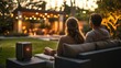 © Nathaphat - Romantic Outdoor Patio Retreat: Couple Relaxing with Streaming Music and Garden Views