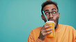 © Jirawatfoto - Expressive Man Enjoying Frozen Beverage Against Gradient Background