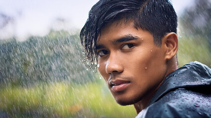 Asian man seeming down or depressed in the rain