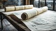 © Ahmad-Muslimin - Rolled up blueprints on a wooden table