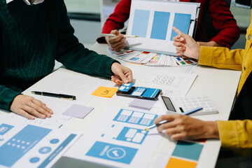 Wall Mural - close up view of ui developer team brainstorming on their project with laptop, smartphone and digita