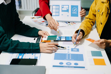 Wall Mural - close up view of ui developer team brainstorming on their project with laptop, smartphone and digita
