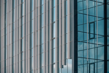 Wall Mural - empty glass windows of a modern building with a reflection of the sky in the glass