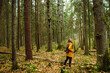 © maxbelchenko - Young woman walks through a pine forest, restoring health and psyche in nature. Forest baths. Active lifestyle.