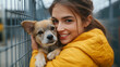 © Ramses - Young adult woman holding adorable dog in animal shelter