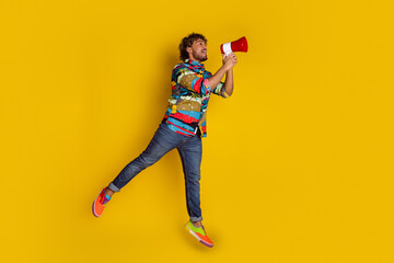 Sticker - Full body photo of attractive young man jump scream megaphone dressed stylish colorful clothes isolated on yellow color background