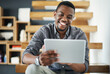 © peopleimages.com - Office, black man and online with tablet for review, reading message and typing email for business deal. Stairs, male person or investor with digital for company performance, feedback and confidence