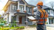 © AdriFerrer - A man in an orange vest is standing in front of a house, holding a clipboard
