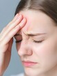 © ChubbySunday - Stressed Woman Experiencing Headache and Rubbing Forehead in Pain
