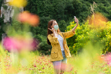 Lifestyle traveler women feeling good relax and happy freedom and see the fire balloon outdoors the nature tea and cosmos farm in the sunrise morning. Travel and summer Concept