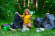© Volodymyr - Child picking plastic trash for cleaning the nature. kid Clean up garbage outdoor. Ecology concept. Environment Day. Save earth. Recycling bin garbage. Ecology. Environmental care. Eco kid.
