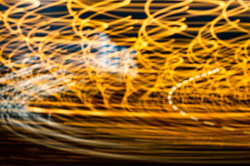 Wall Mural - The image is a blurry, yellowish-orange swirl of light. The colors are vibrant and the lines are wavy, giving the impression of movement and energy. Scene is dynamic and lively