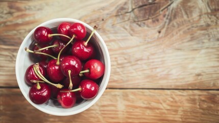 Wall Mural - A bowl filled with luscious, ripe cherries resting on a rustic wooden table, evoking a sense of fresh summer fruit and rustic charm.