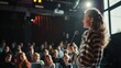 © VK Studio - A young woman passionately speaking on stage to an engaged audience, capturing the essence of public speaking and communication.