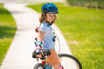 Poster - Kids first bike. Child learning to ride bike. Kid riding bike in a helmet. Child with a childs bike and in protective helmet. Articles on safety and summer activity. Happy kid boy having fun in park.