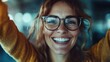 © Maximages  - A joyful woman wearing glasses is celebrating a happy moment, smiling broadly and creating an energetic and lively scene that exudes positivity and warmth to the viewer.