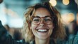 © Maximages  - A woman with glasses is pictured smiling energetically and joyfully at the camera. This image captures a lively moment filled with positivity and vibrant energy, radiating happiness.