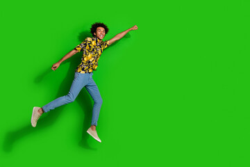 Sticker - Photo of optimistic positive glad man wear trendy summer print clothes fly air empty space isolated on green color background