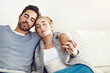 © SunriseDon/peopleimages.com - Couple, sleep and hug together on sofa to relax, rest and cuddle in marriage, relationship or love for partner. Tired, man and woman dreaming with peace in home, house or living room in morning