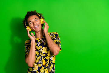 Canvas Print - Photo of cool optimistic man wear stylish summer print outfit enjoy music empty space isolated on green color background