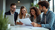 © Andrew505 - Team of Business Professionals Discussing Documents in a Modern Office Environment