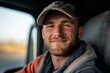 © Milos - A young man with a cap smiles warmly inside a vehicle, conveying a sense of contentment and readiness as he appears engaged in his work or journey on the road.