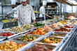 © Alona - Food Service. Chef Behind Full Lunch Station with Assortment of Trays in School Cafeteria