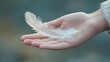© Jakraphong - Delicate Hand Holding Feather Symbolizing Lightness and Freedom with Soft Background