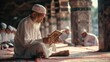© Sirichat. Camphol - Muslim children and old men teaching in white shirts are praying and reading Islamic religious books.
