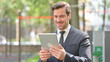 © Mustansar - Portrait of Young Businessman Doing Video Chat on Tablet Outdoor