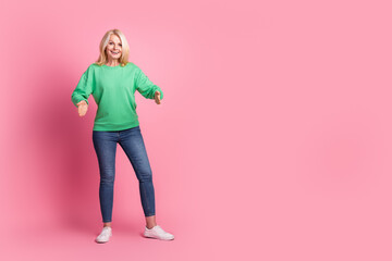 Canvas Print - Full body photo of attractive retired woman hold carry empty space dressed stylish green clothes isolated on pink color background