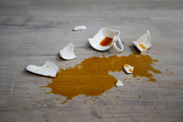 Wall Mural - A broken cup of coffee fell on laminate, coffee spilled on floor.